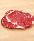 Raw steak on a wooden cutting board