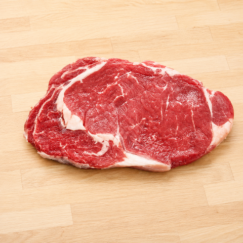 Raw steak on a wooden cutting board